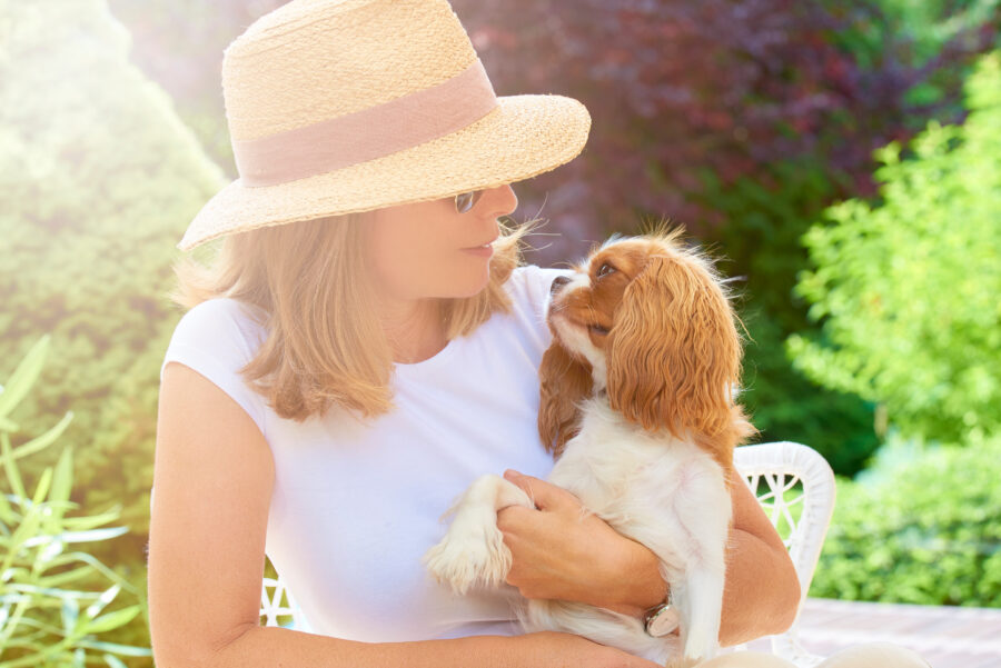 image of woman holding a small dog in her arms, woman smiling at the dog and dog looking back at woman. How to give your dog a better life